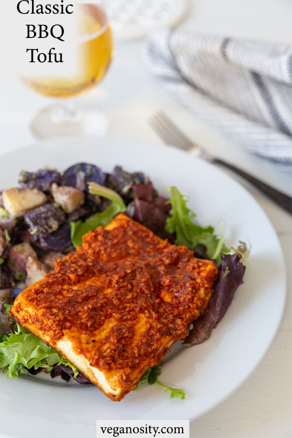 A Pinterest pin for crispy bbq tofu with a picture of the tofu and potato salad on a white plate. 