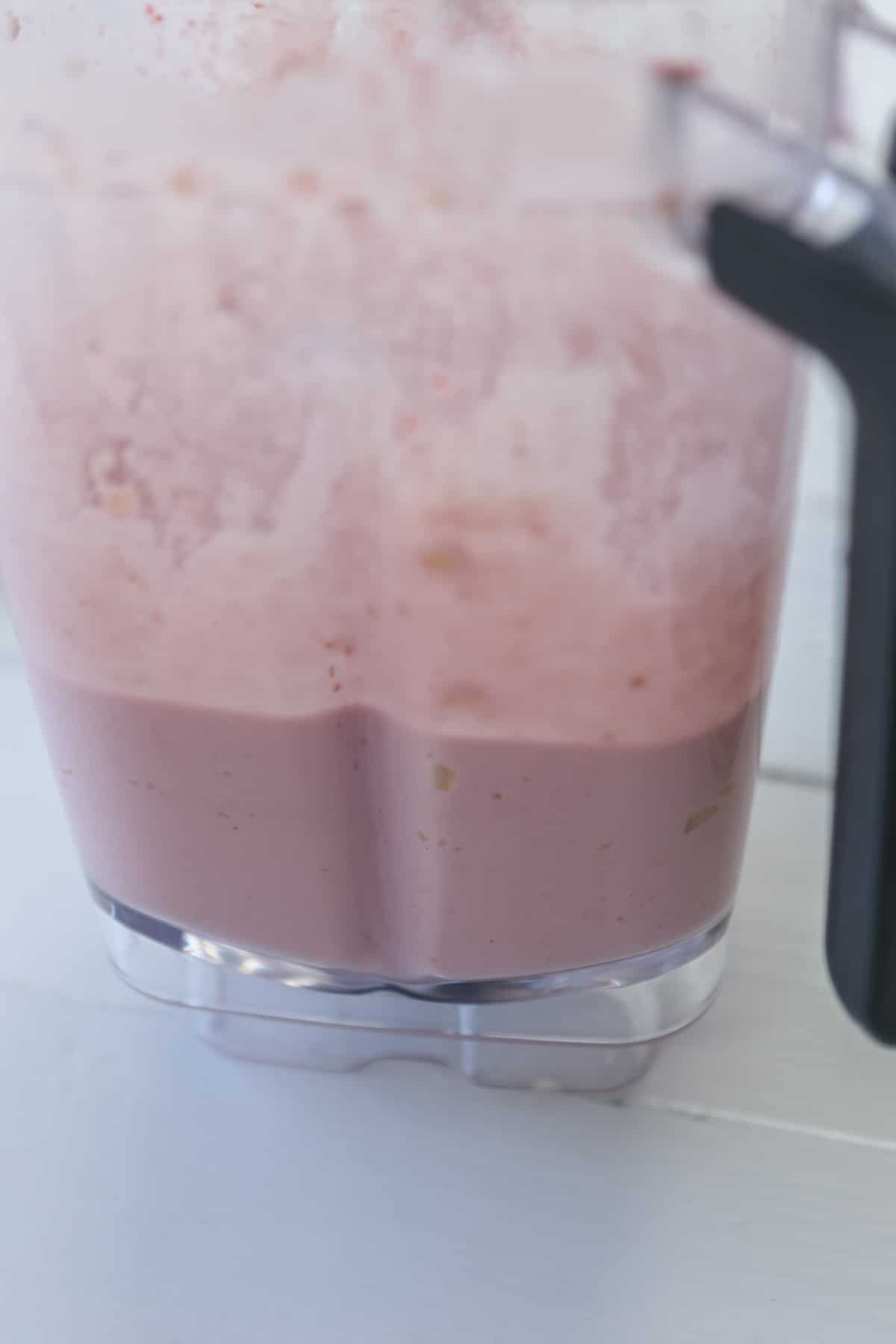 A blender filled with raspberry cheesecake filling. 