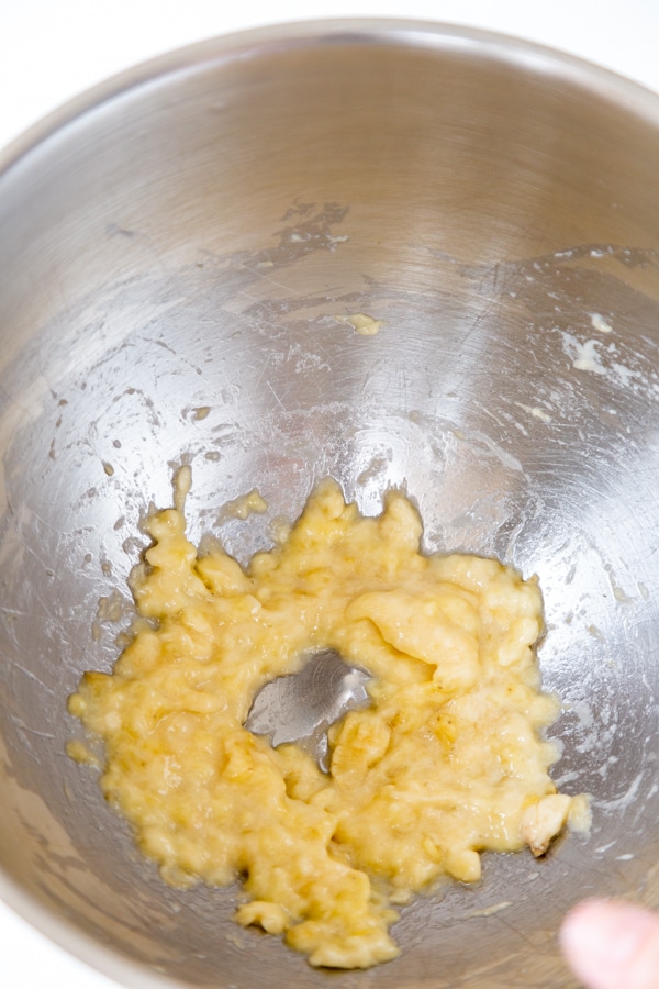 A silver mixing bowl with banana puree.