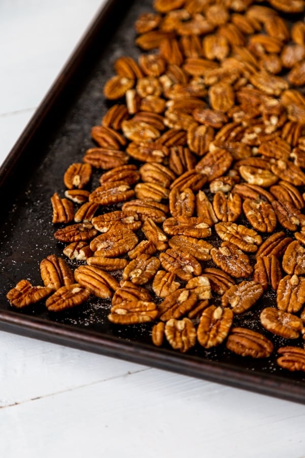 A rimmed baking sheet filled with toasted pecans.