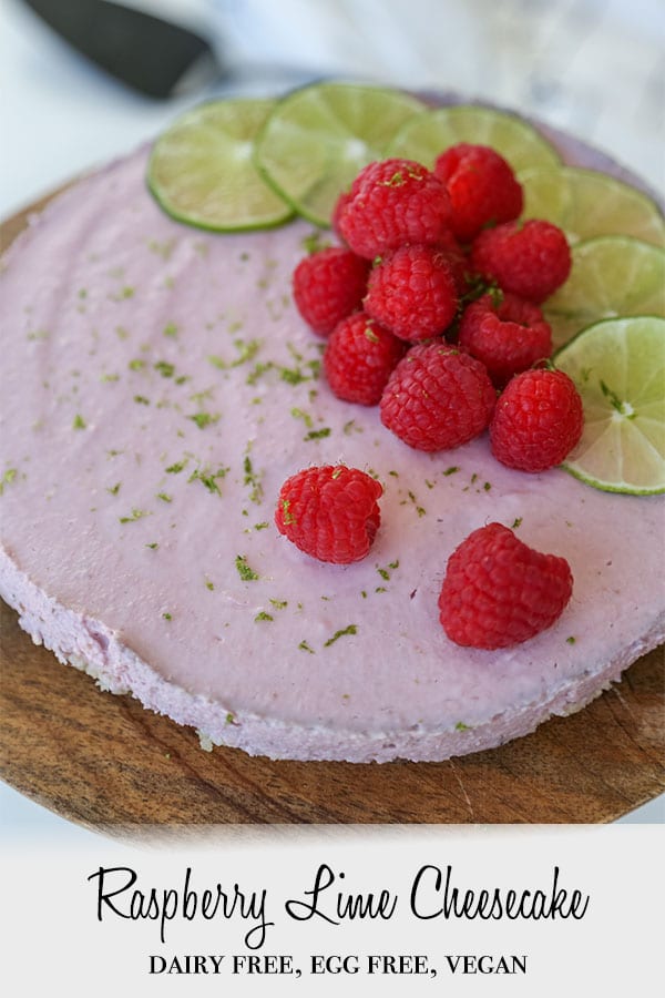 A Pinterest pin for raspberry lime cheesecake with the whole cake on a wooden cake stand. 