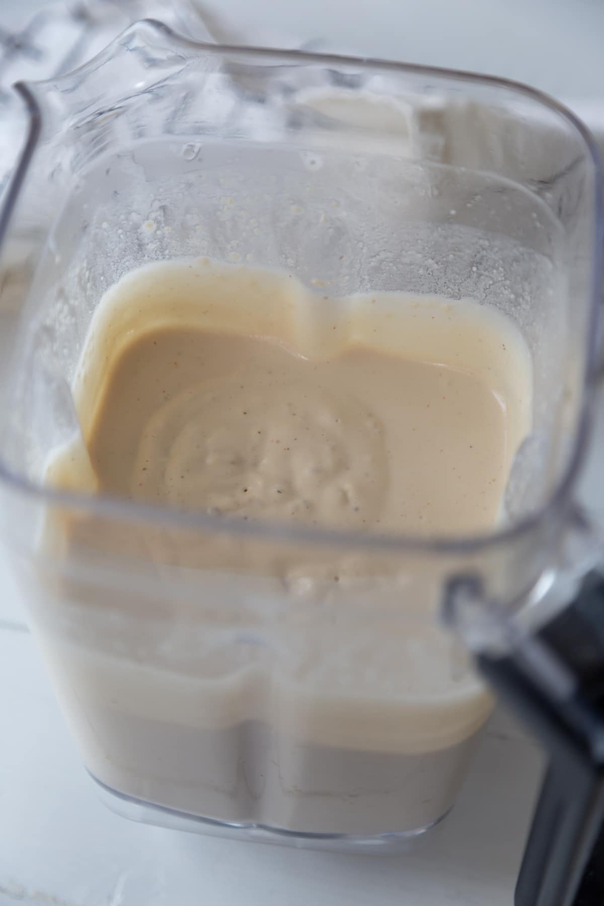 A blender with white cream sauce.