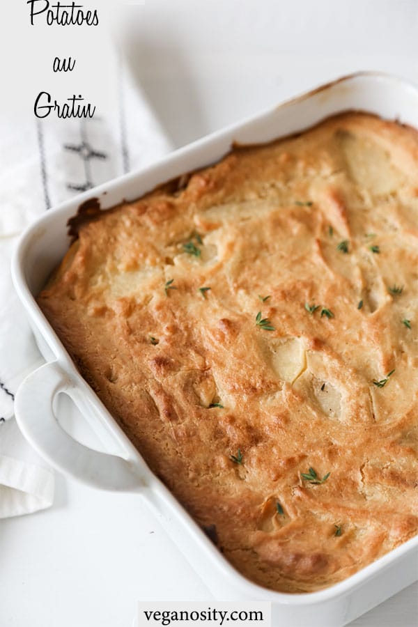 A Pinterest pin for vegan potatoes au gratin with a white baking dish of the golden brown gratin sprinkled with minced thyme.