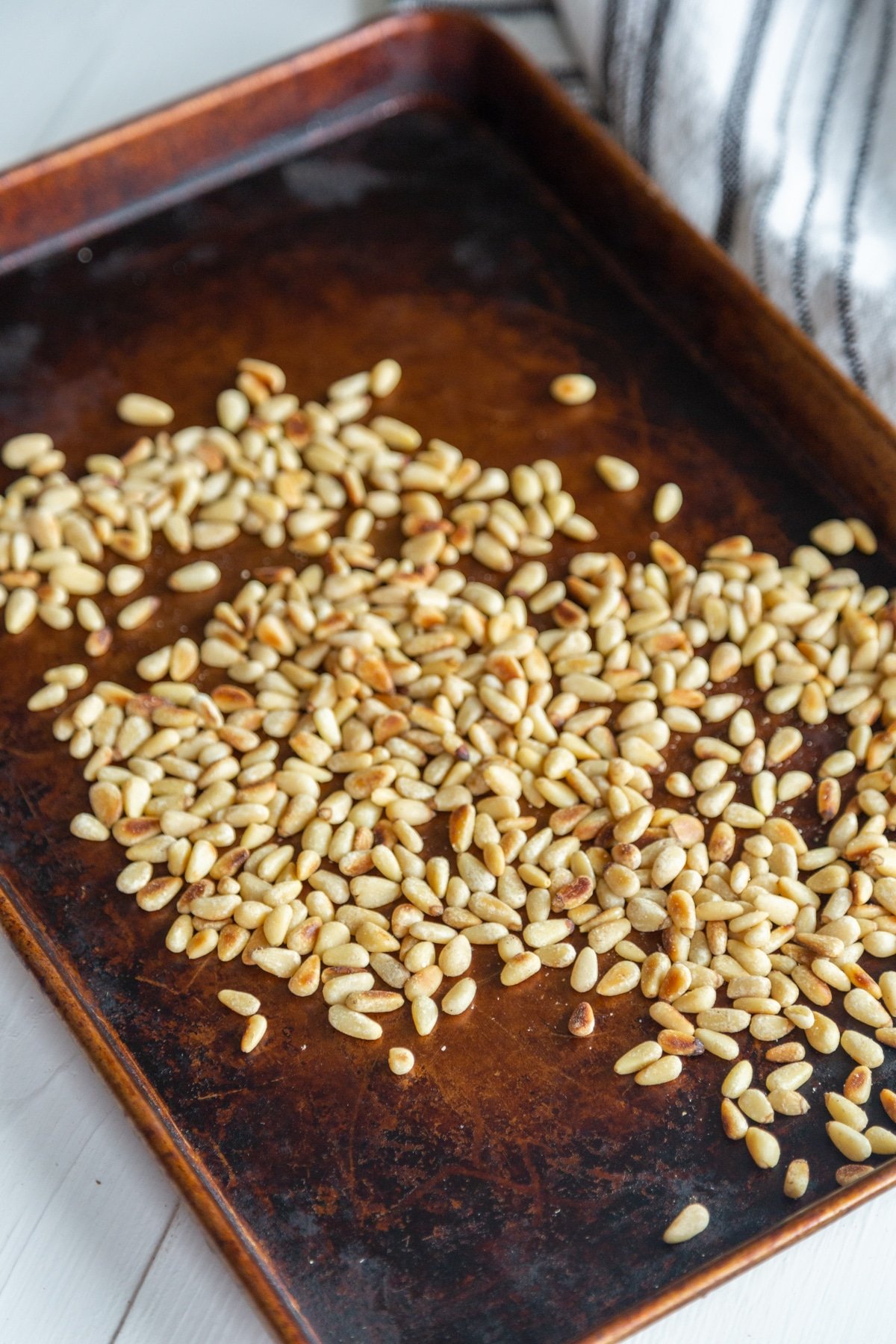 Toasted Pine Nuts on a rimmed baking sheet.