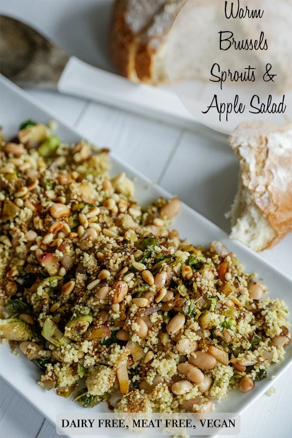 A Pinterest pin for a warm couscous, Brussels Sprouts, and apple salad with a picture of a rectangular platter with the salad.