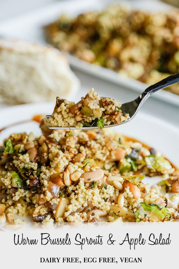A Pinterest pin for Warm Couscous & Brussels Sprouts Salad with a picture of a white plate with the salad and a fork full of the salad being held over the plate.