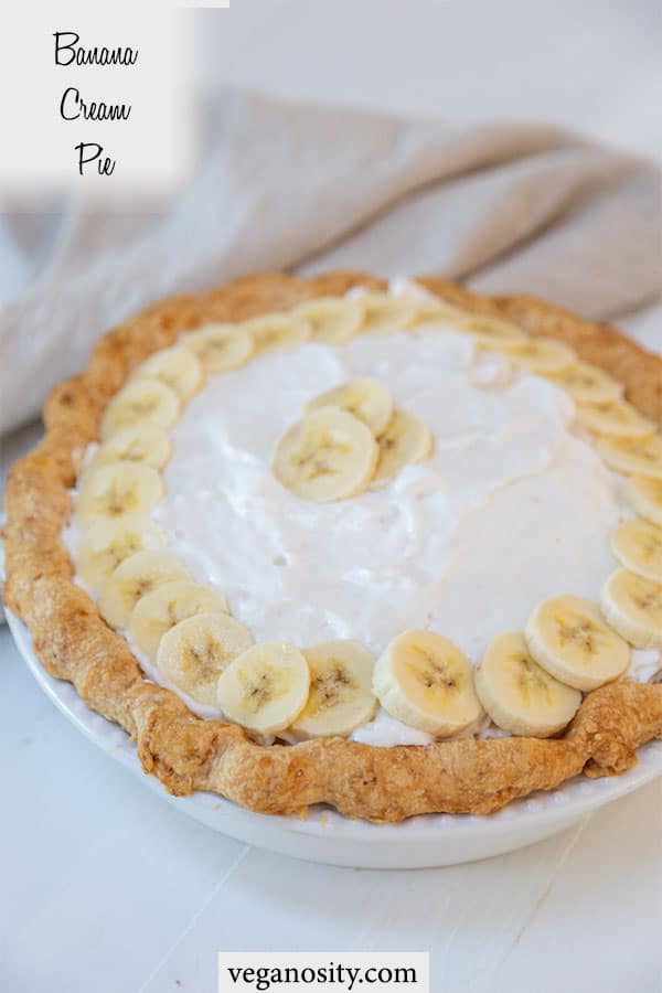 A Pinterest pin for vegan banana cream pie with a picture of the whole pie with whipped topping and banana slices.