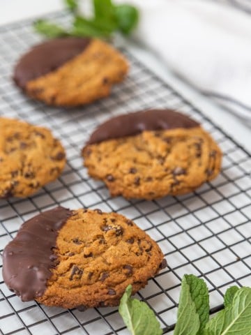 Cookies dipped in chocolate on a wire rack.