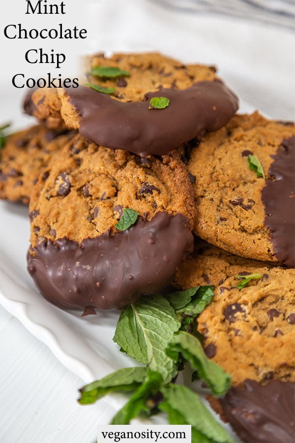 A Pinterest pin for vegan chocolate chip mint cookies with a picture of a white platter of the cookies with mint leaves.