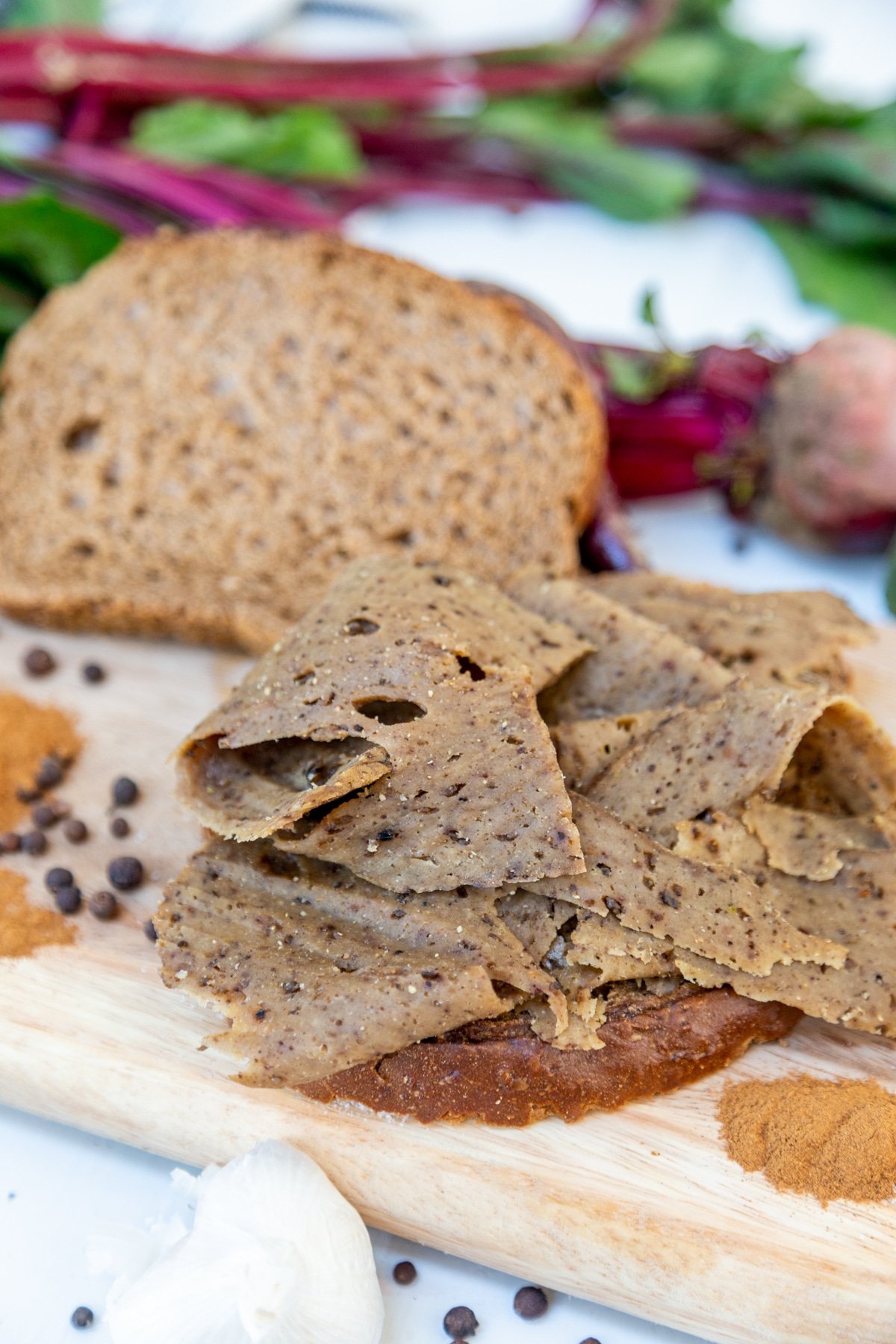 Sliced corned beef on a slice of rye bread with another slice of bread next to it.