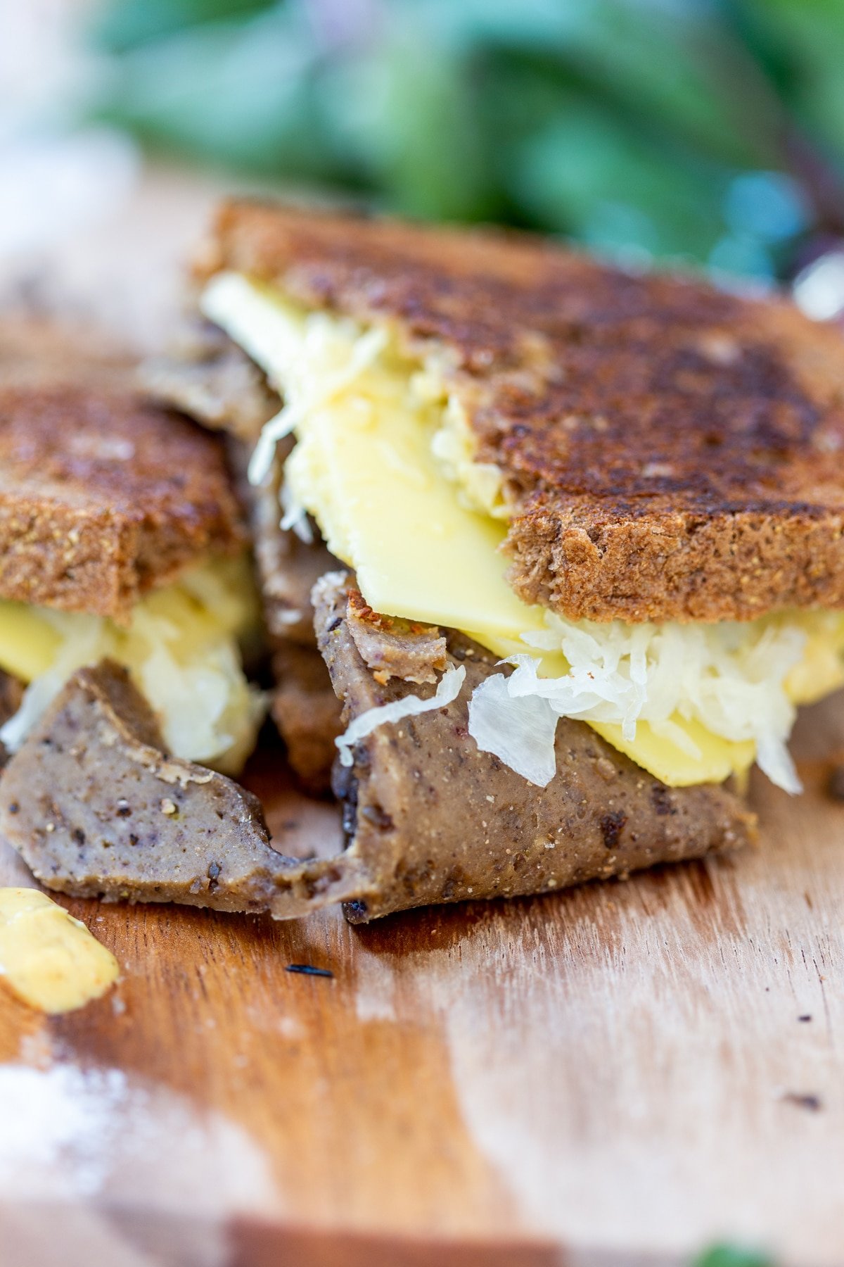 A Reuben sandwich on a wooden board.