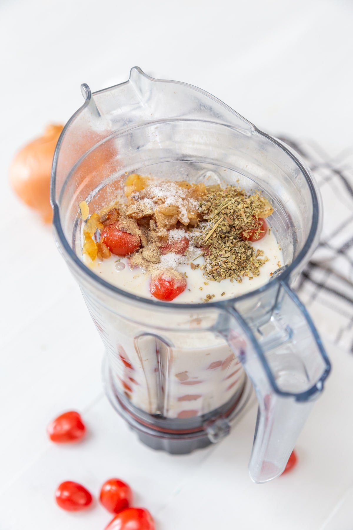 A blender with ingredients for vodka sauce.