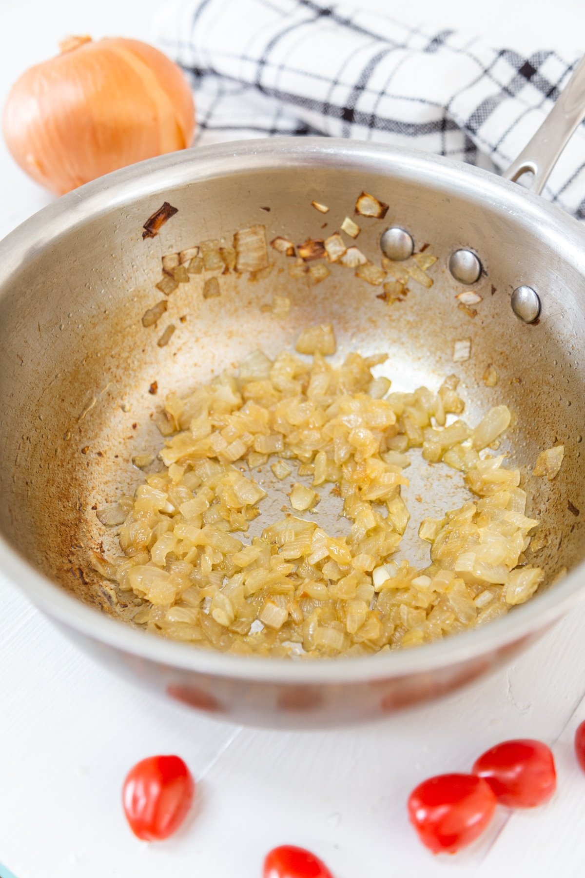 A copper pan with chopped caramelized onion.