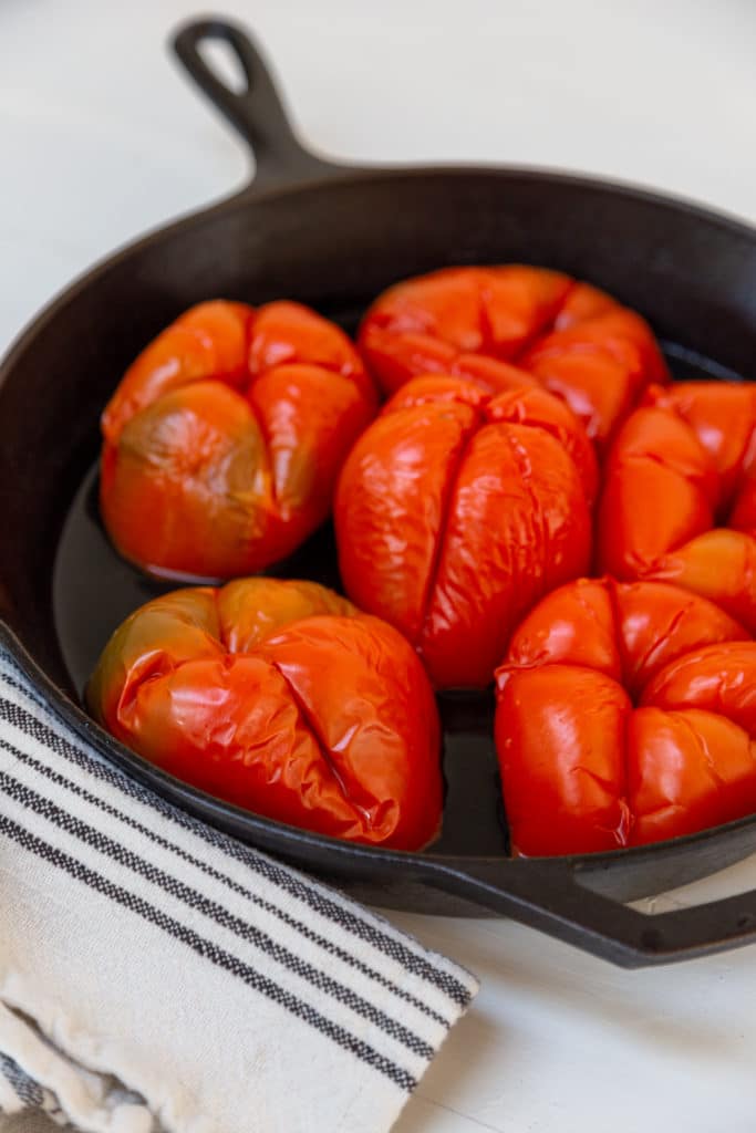 6 roasted red bell peppers in a cast iron skillet.