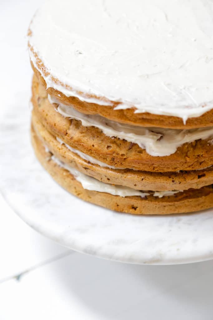 4 layers of carrot cake with frosting between each layer and spread evenly on the top layer.