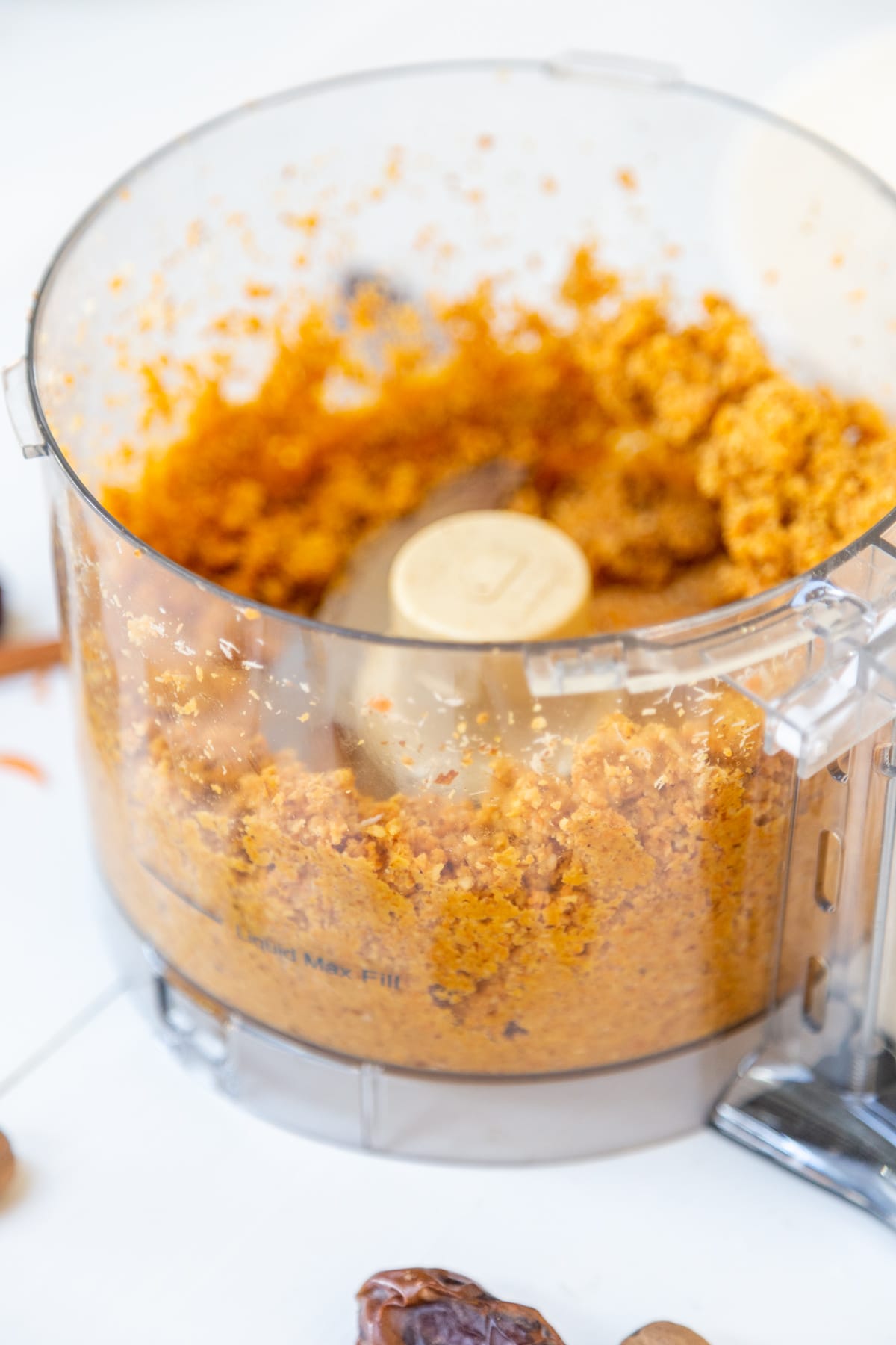 A food processor with ground ingredients for carrot bites.