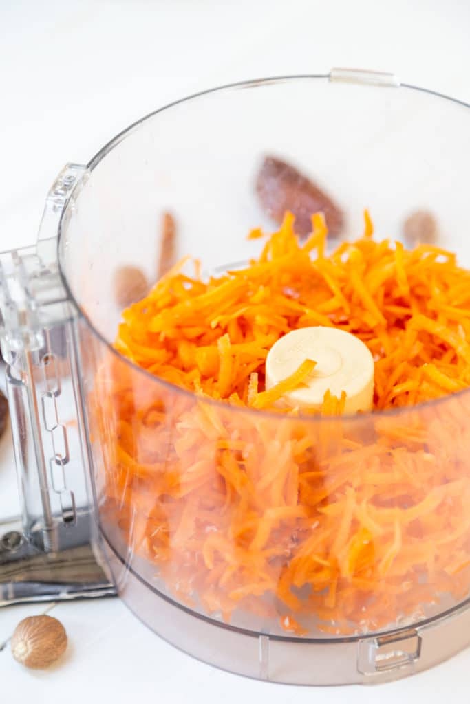 A food processor with shredded carrots.