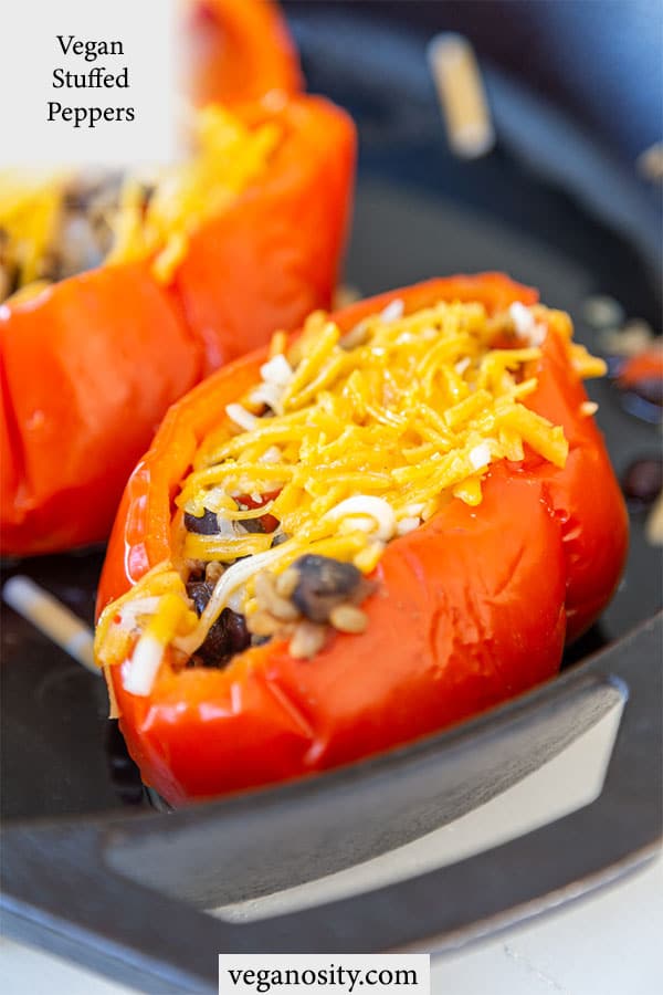 A Pinterest pin for vegan stuffed peppers with 2 peppers in a black pan.