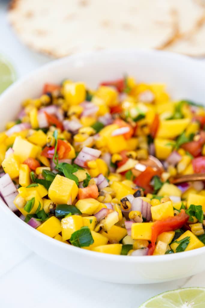 A white bowl with mango salsa.