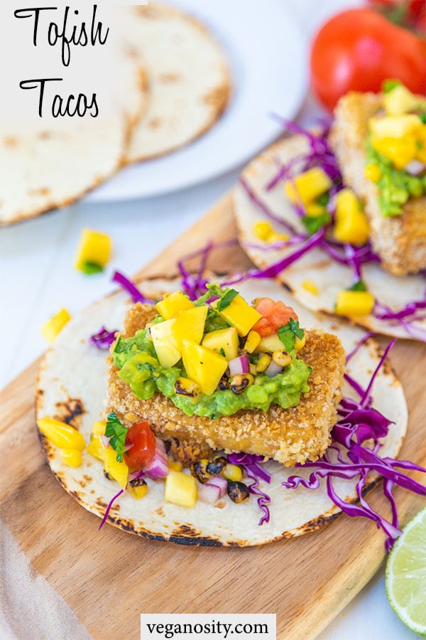 A Pinterest pin for vegan fish tacos with a picture of the tacos on a wooden board.