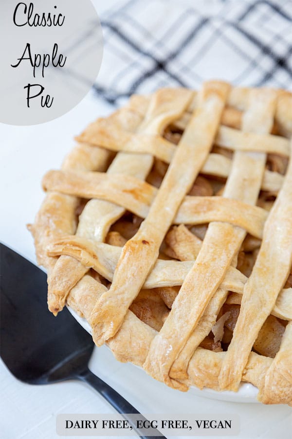A Pinterest pin for vegan apple pie with a picture of a whole pie with a lattice tip, and a black spatula next to the pie.