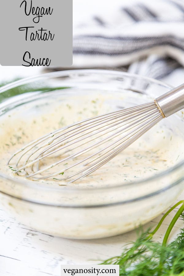 A Pinterest pin for vegan tartar sauce with a picture of a clear glass mixing bowl of the sauce being whisked.