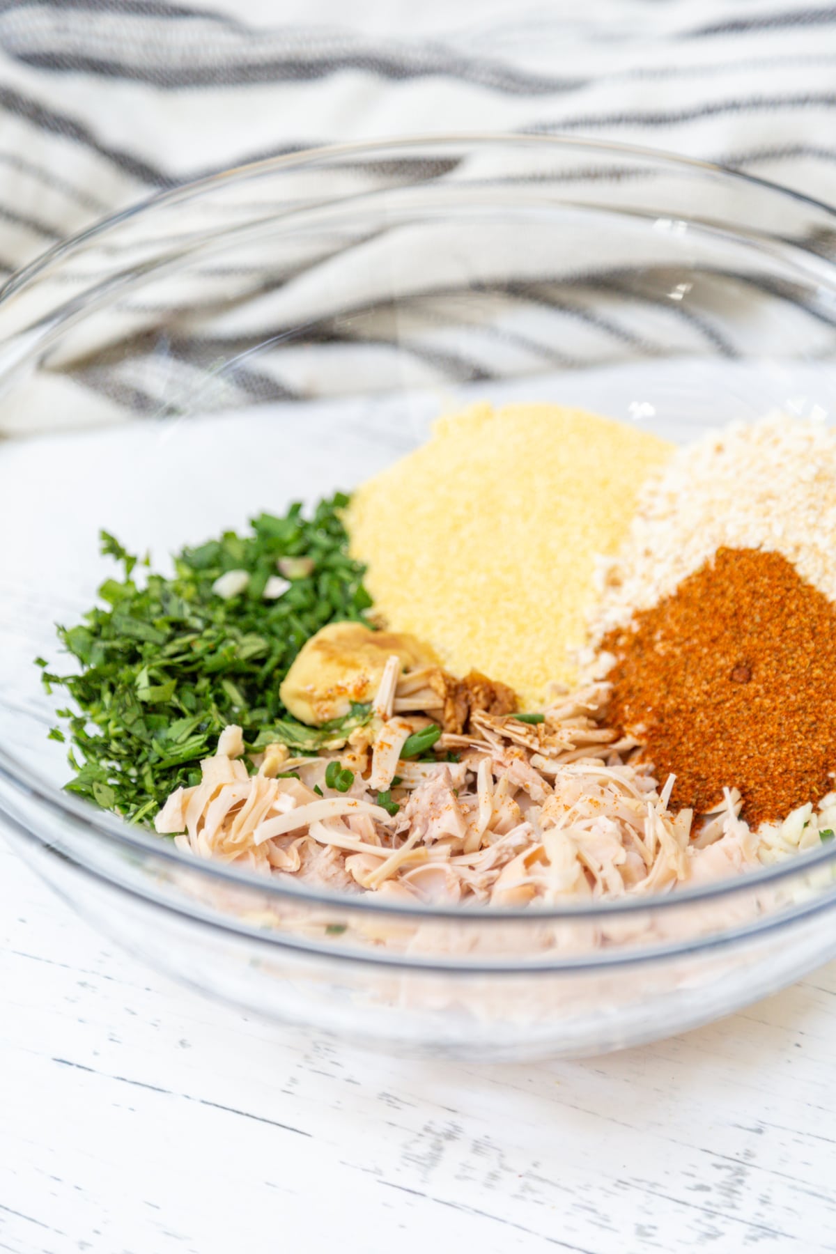 A glass bowl with ingredients for jackfruit crab cakes.