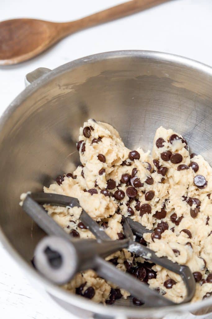A silver mixing bowl with chocolate chip cookie dough.