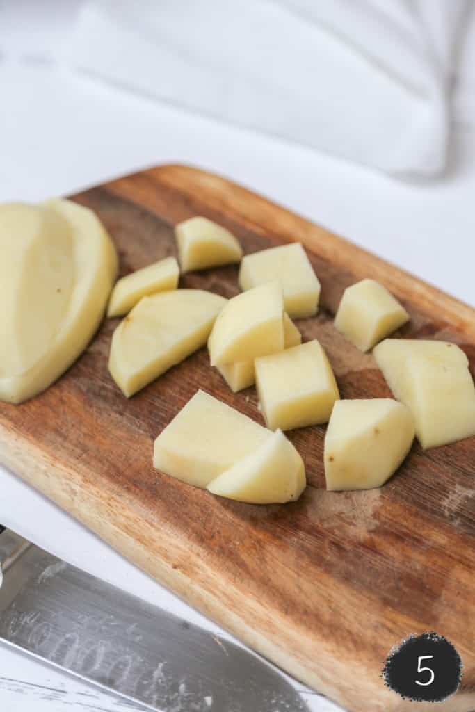 Diced potatoes on a wood cutting board. 