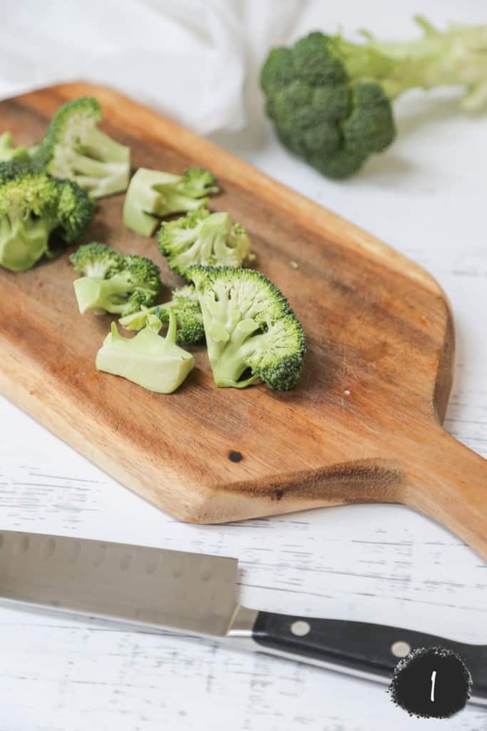 Chopped broccoli on a wood cutting board. 
