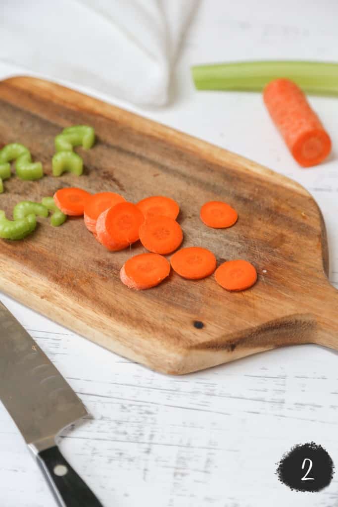 Sliced carrots and chopped broccoli on a wood cutting board. 