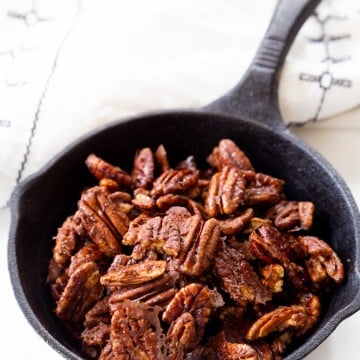 A cast iron skillet filled with cinnamon pecans.