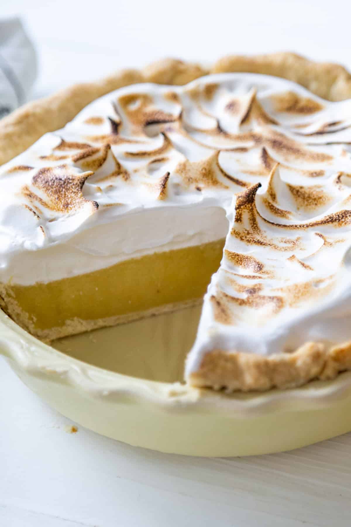 A lemon meringue pie with a slice removed.