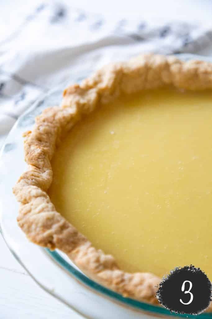 A lemon pie with a white towel next to it.