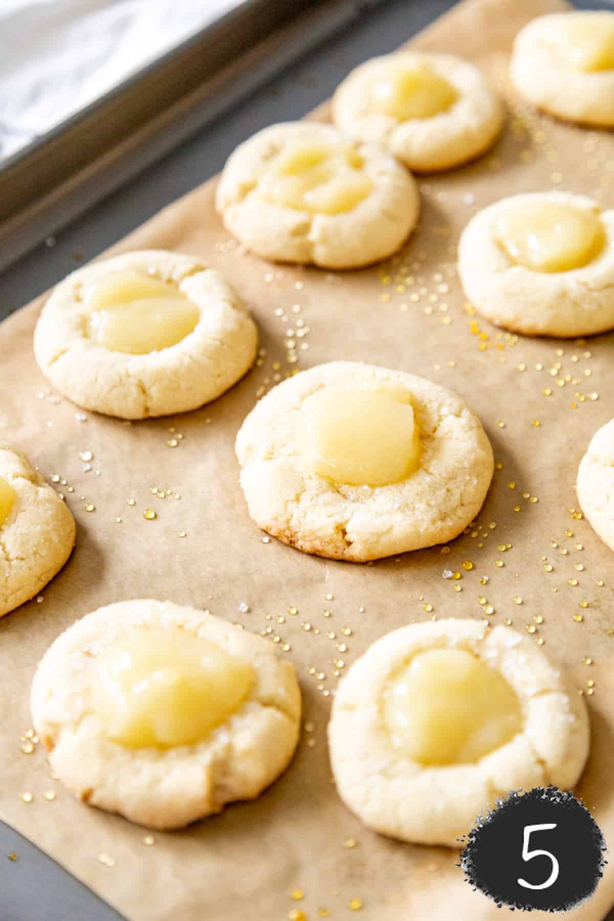A cookie sheet with lemon thumbprint cookies.