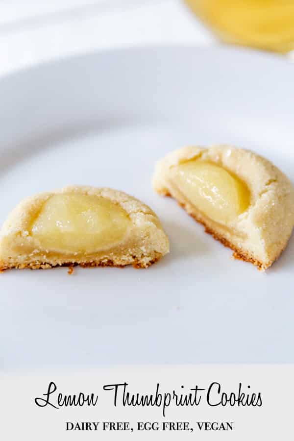 A PInterest pin for vegan lemon thumbprint cookies with a picture of the cookie broken in half on a white plate.