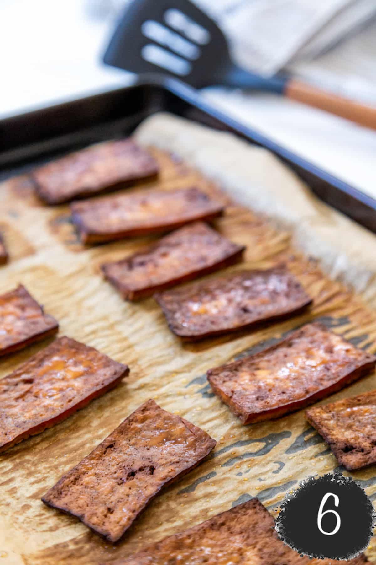 A baking sheet with baked tofu bacon.