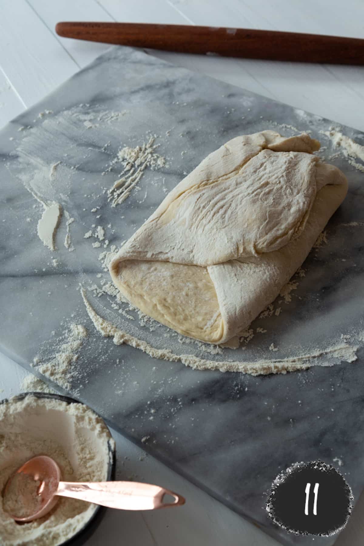 3 sides of croissant dough folder over a block of butter.