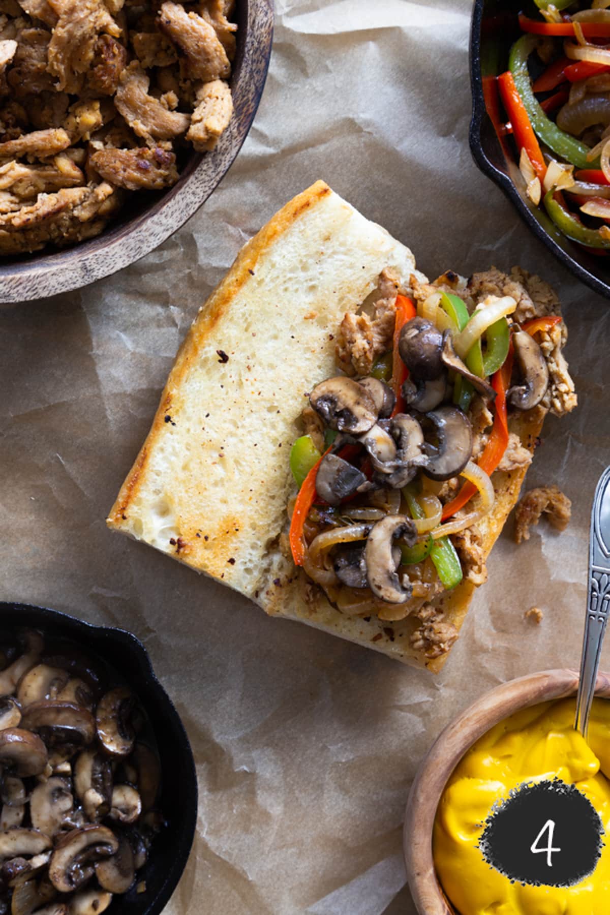 A sandwich with mushrooms, onions, and peppers.