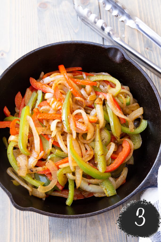 A skillet with cooked onion and peppers.