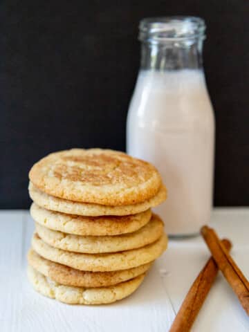 A stack of snickerdoodle cookies with a jar of milk.