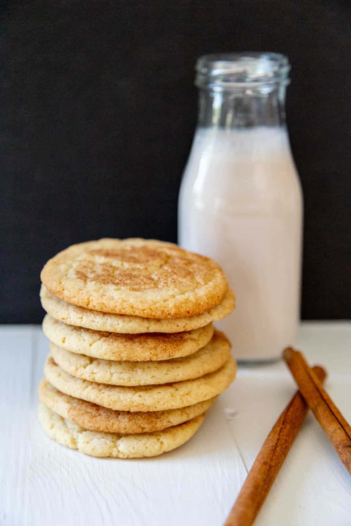 A stack of snickerdoodle cookies with a jar of milk.