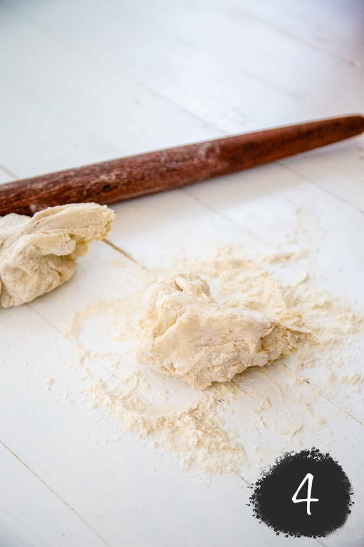 2 pieces of pizza dough and a wooden rolling pin.