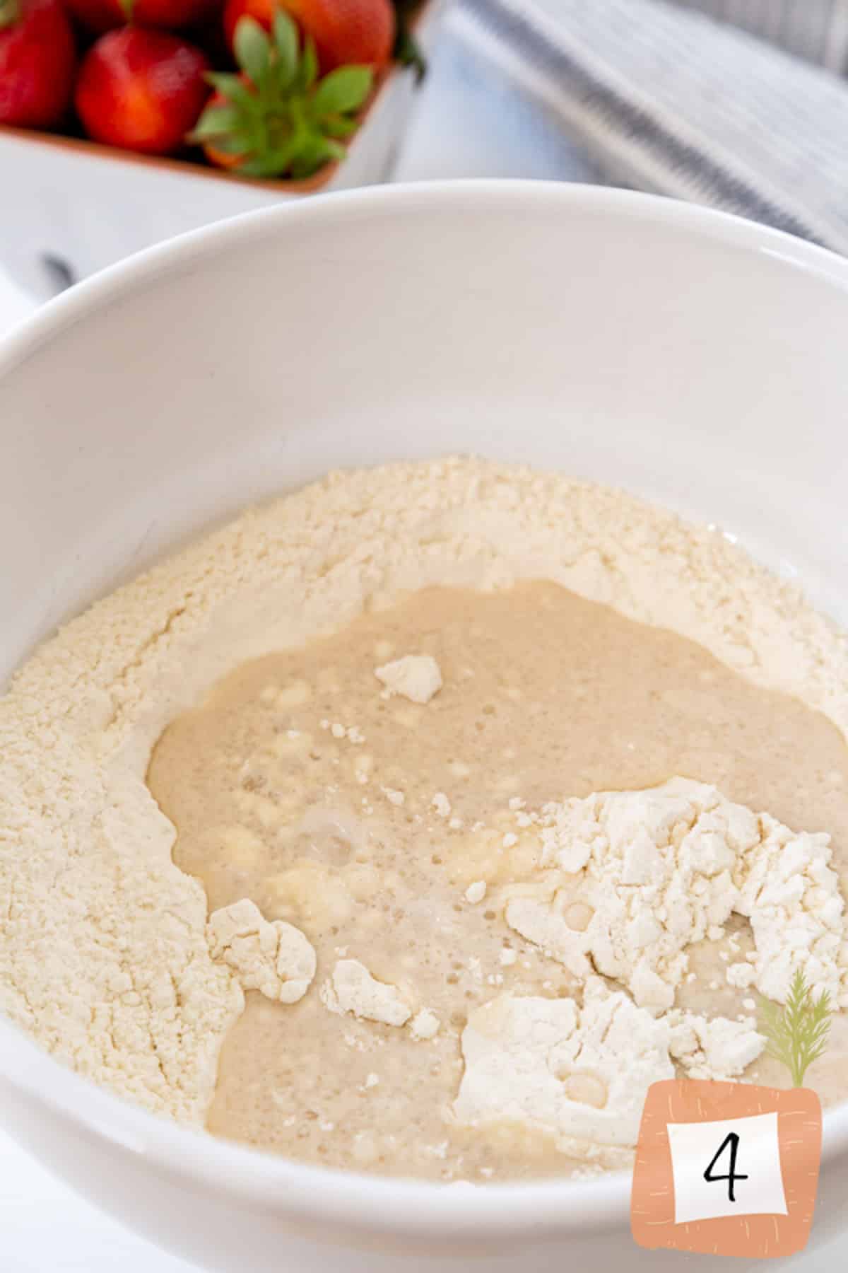 A white bowl with flour and milk.