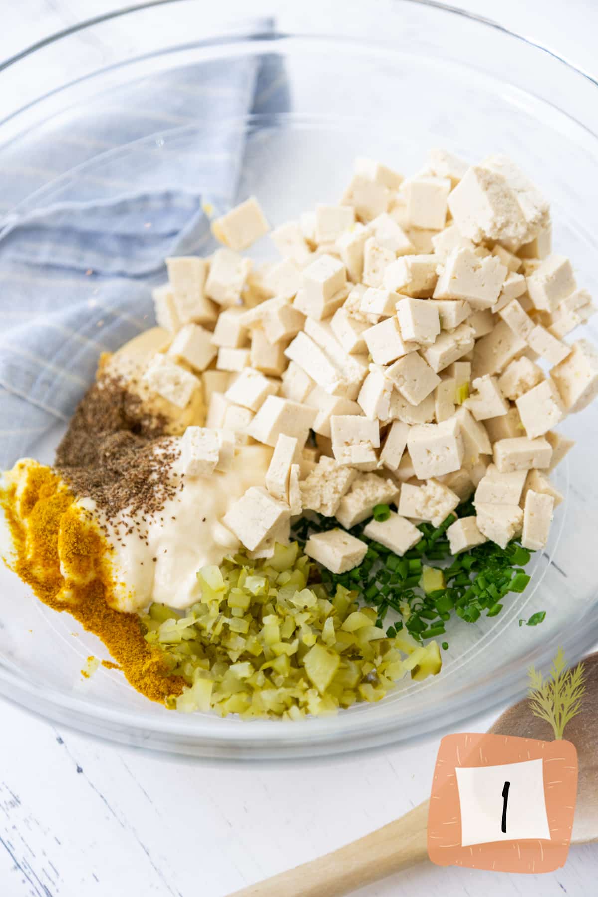 Cubed tofu and spices in a glass mixing bowl.