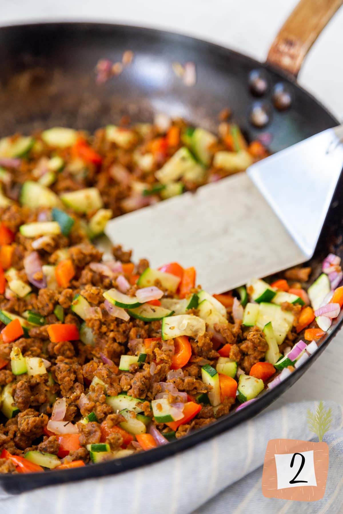 A cast iron pan with sautéed vegetables and vegan chorizo.