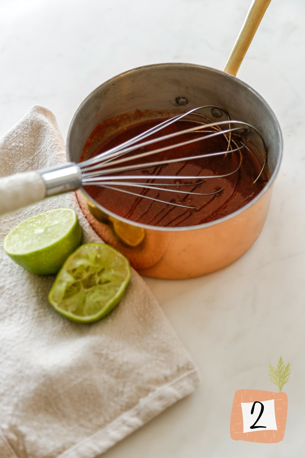 A copper sauce pan with a whisk and barbecue sauce.