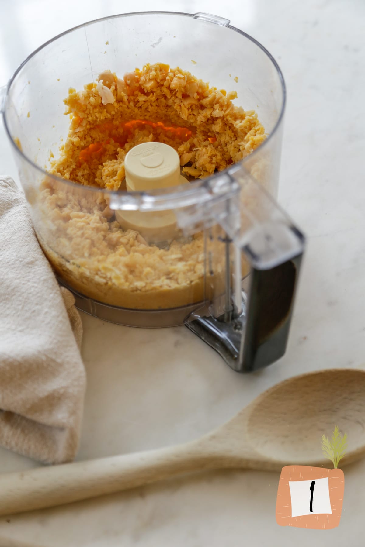 A food processor with ingredients for chickpea burgers.