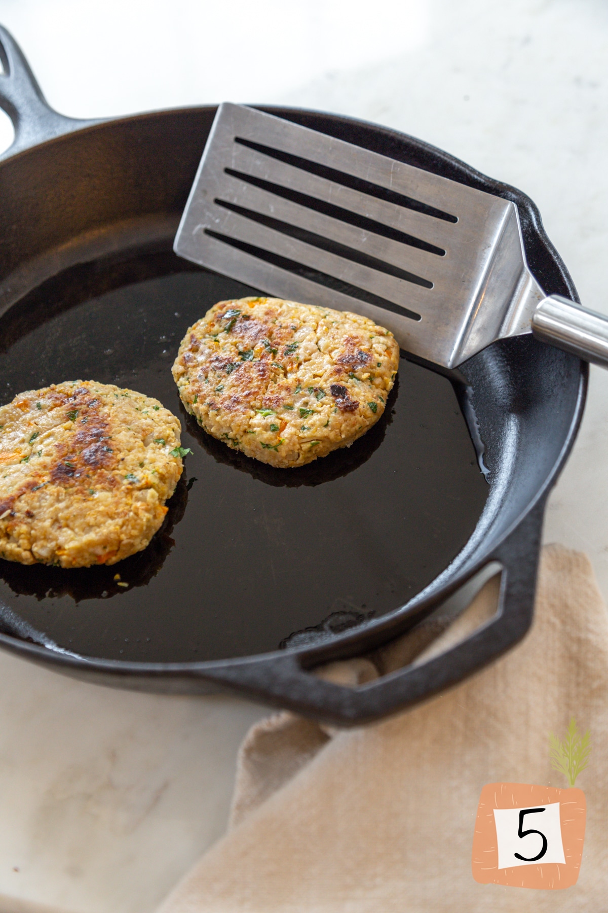 Cooked chickpea burgers in a frying pan.