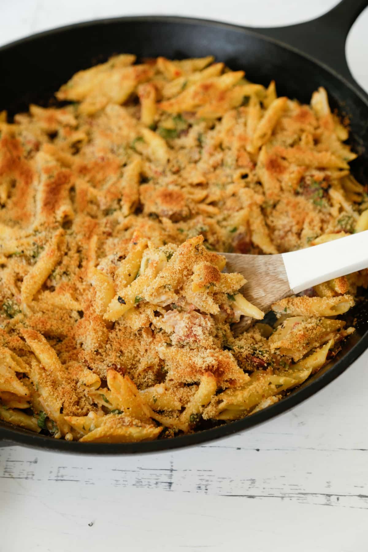 Baked penne pasta in an iron skillet.